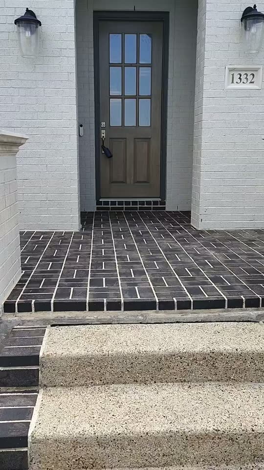 Curb Appeal walking a freshly power washed brick paver porch in front of a white brick home